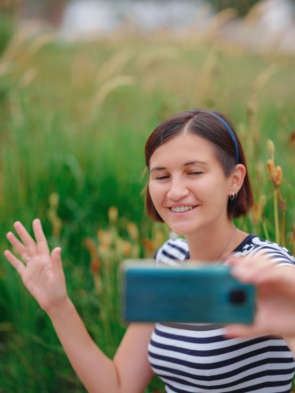 Portrait of young woman in park with smartphone