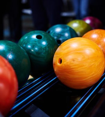 Stand with colorful bowling balls in club